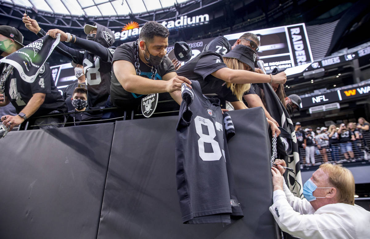 El propietario de los Raiders, Mark Davis, firma autógrafos para los fans antes del partido de ...
