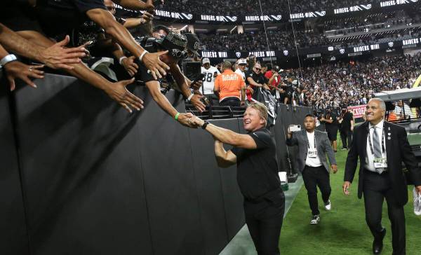 El entrenador en jefe de los Raiders, Jon Gruden, celebra con los fans después de una victoria ...