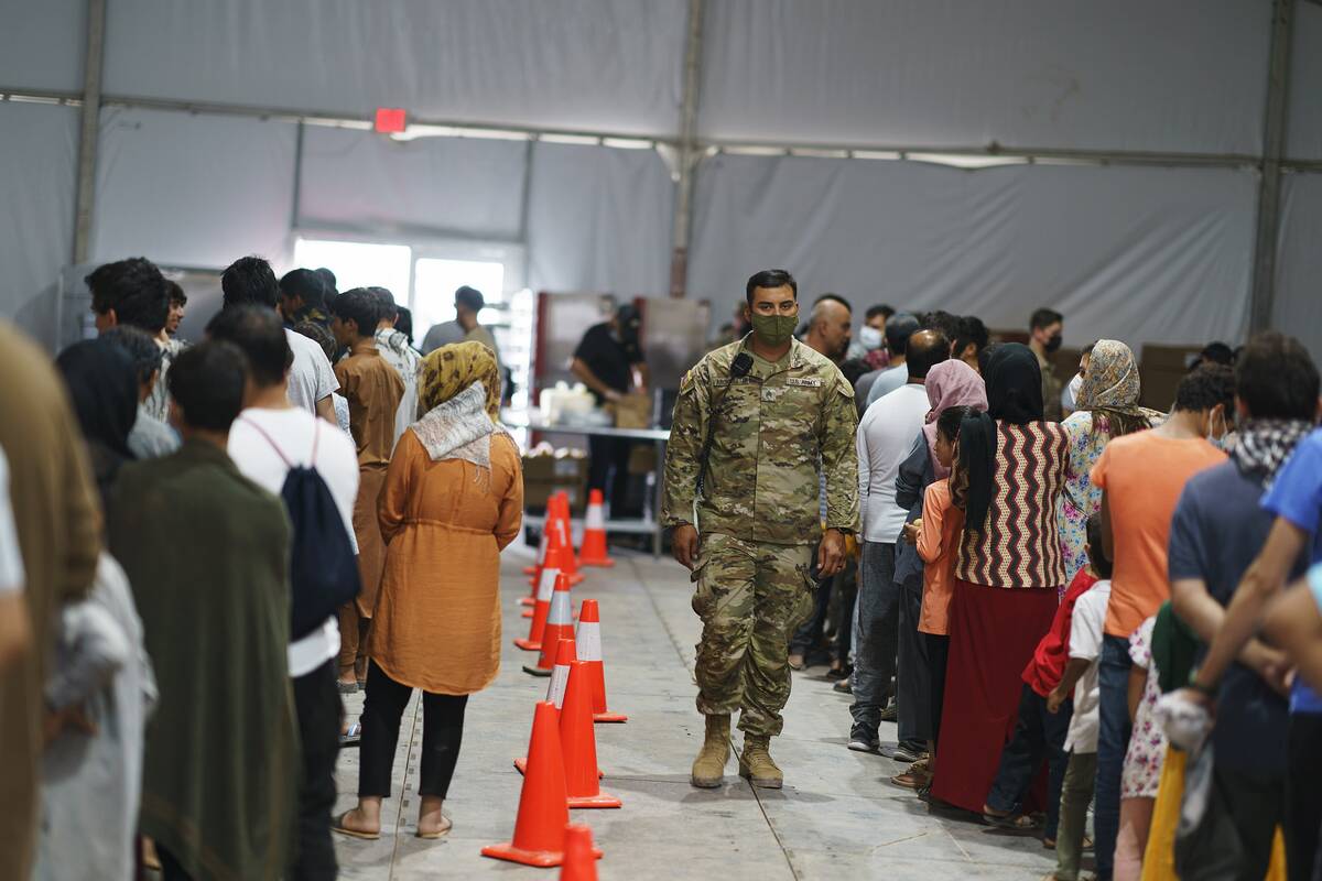 Refugiados afganos hacen fila para recibir comida en un comedor en la Aldea Doña Ana de Fort B ...