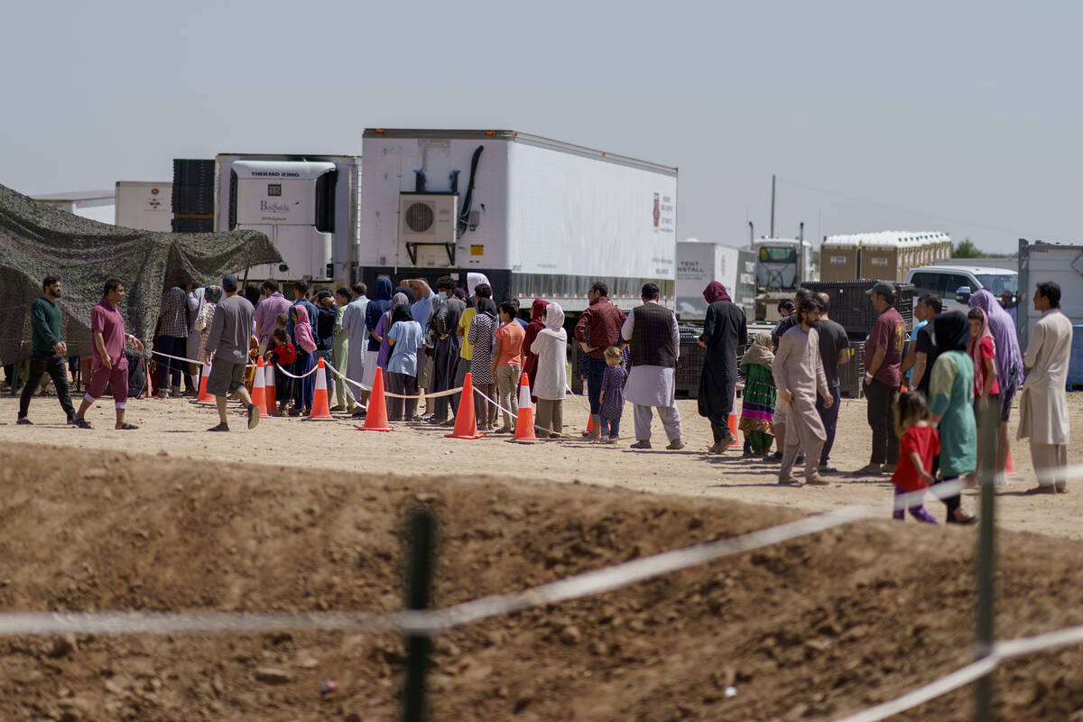 Refugiados afganos hacen fila para recibir comida fuera de un comedor en la Aldea Doña Ana de ...