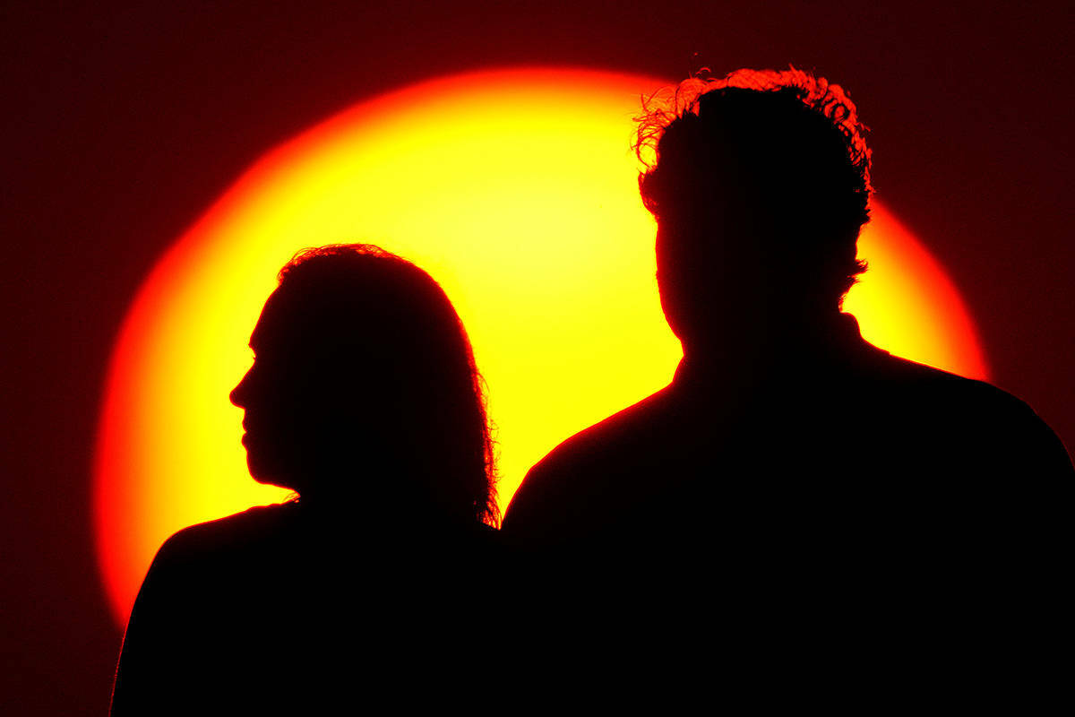 Una pareja observa la puesta de sol desde un parque el sábado 10 de julio de 2021 en Kansas Ci ...