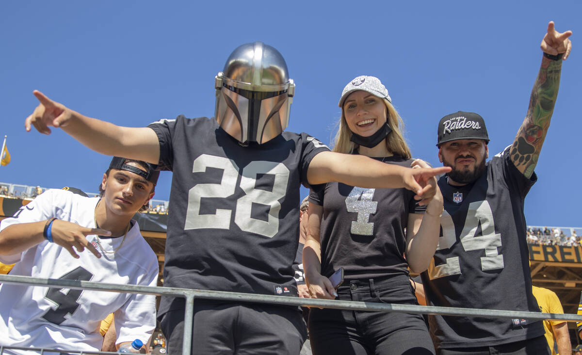 Fans de los Raiders animan al equipo durante el calentamiento antes de un partido de fútbol am ...
