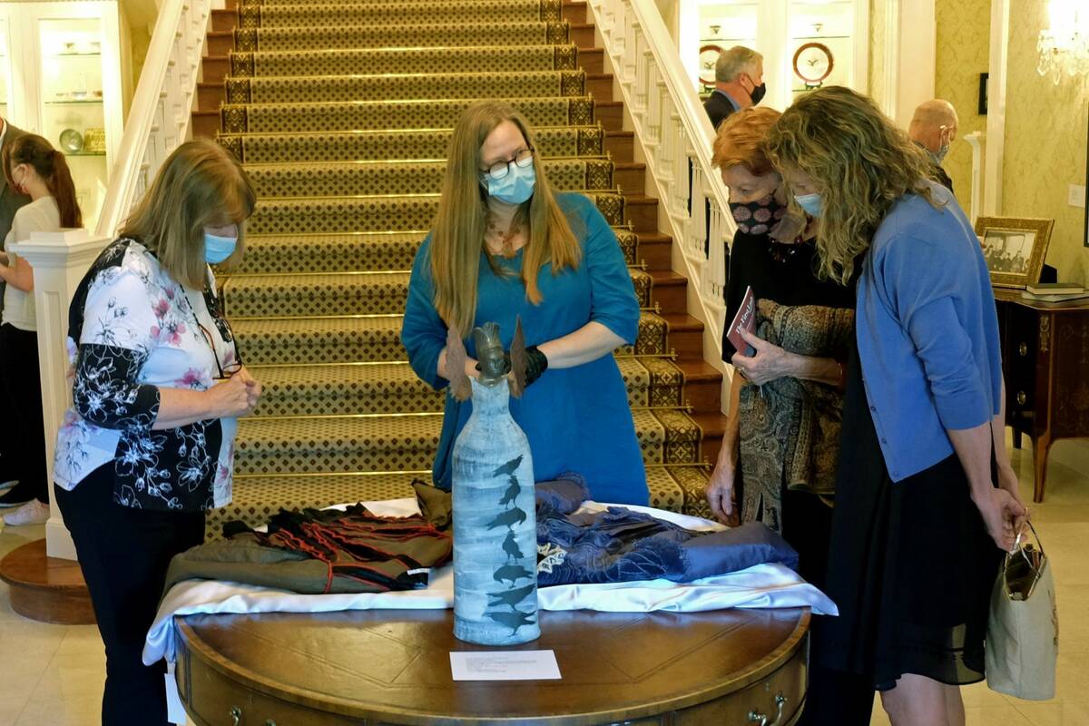 Los visitantes miran las telas que se exhiben el lunes como parte de una exposición en la mans ...