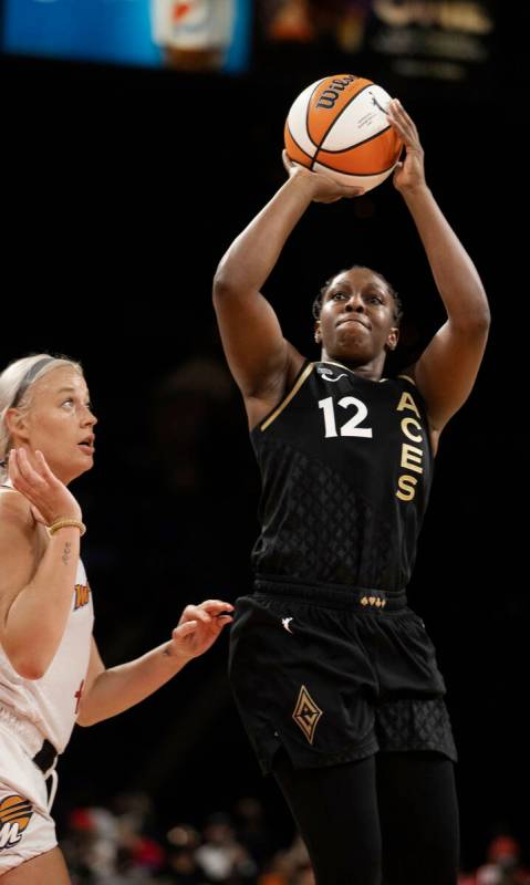 La jugadora de Las Vegas Aces, Chelsea Gray (12), dispara sobre su rival de Phoenix Mercury, So ...