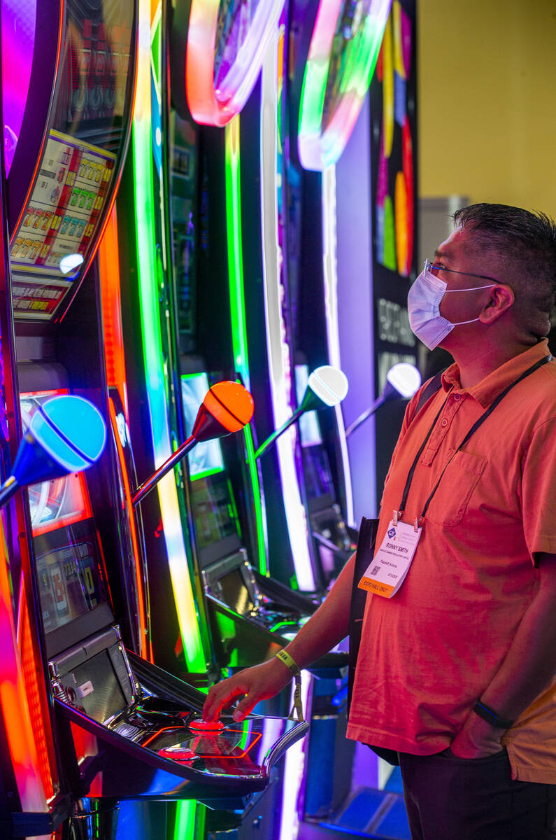 Ronny Smith juega en una tragamonedas en el espacio de exposición de IGT durante el tercer dí ...