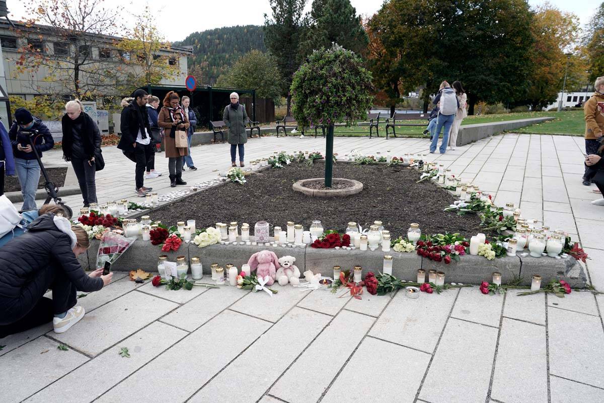 Flowers and candles are left after a man killed several people, in Kongsberg, Norway, Thursday, ...