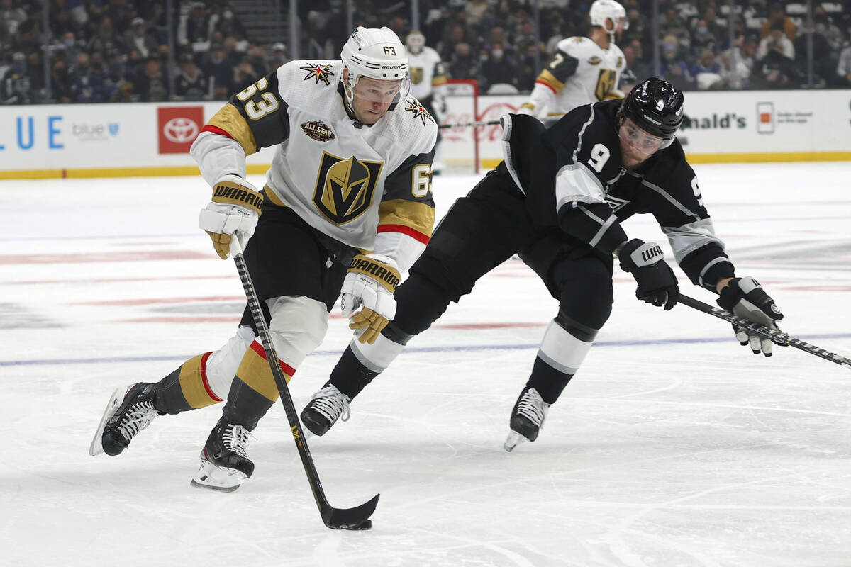 El delantero de los Vegas Golden Knights Evgenii Dadonov (63) aleja el puck del delantero de lo ...