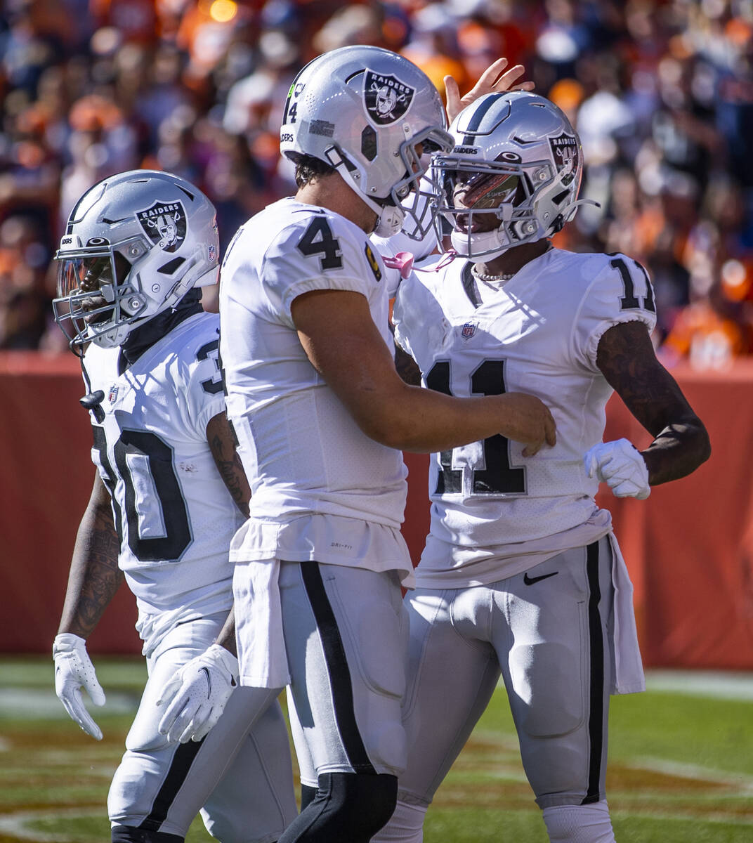 El quarterback de los Raiders, Derek Carr (4), celebra un touchdown de su compañero de equipo ...