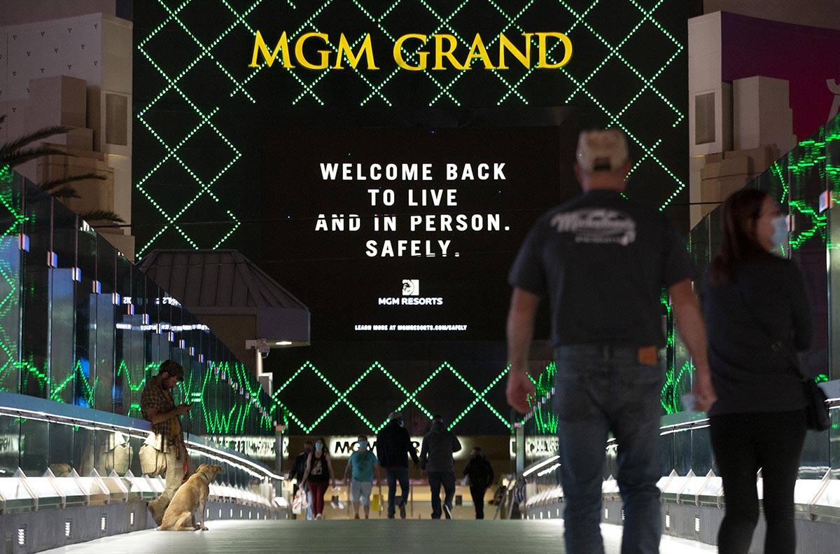Una marquesina del MGM Grand hace referencia al coronavirus mientras los visitantes cruzan un p ...