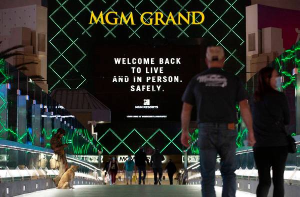 Una marquesina del MGM Grand hace referencia al coronavirus mientras los visitantes cruzan un p ...