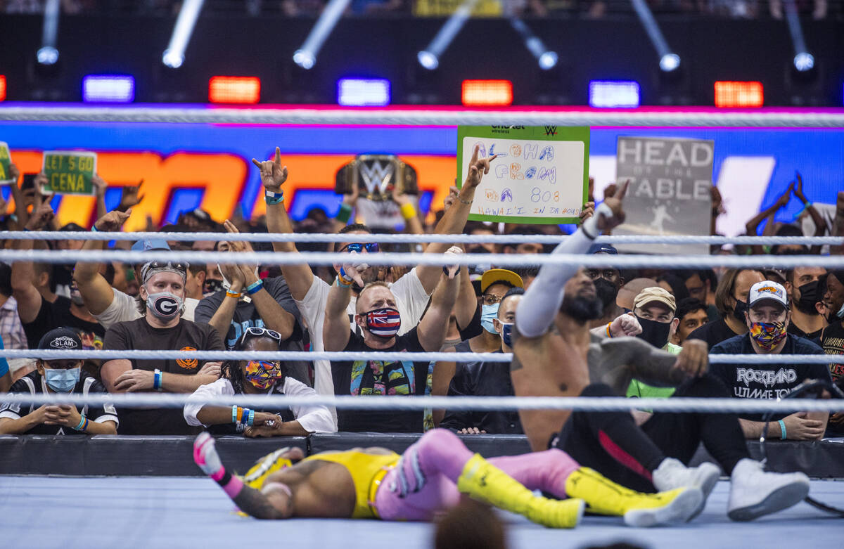 Los fans celebran mientras Jimmy Uso, a la derecha, derriba a Dominik Mysterio en el SmackDown ...
