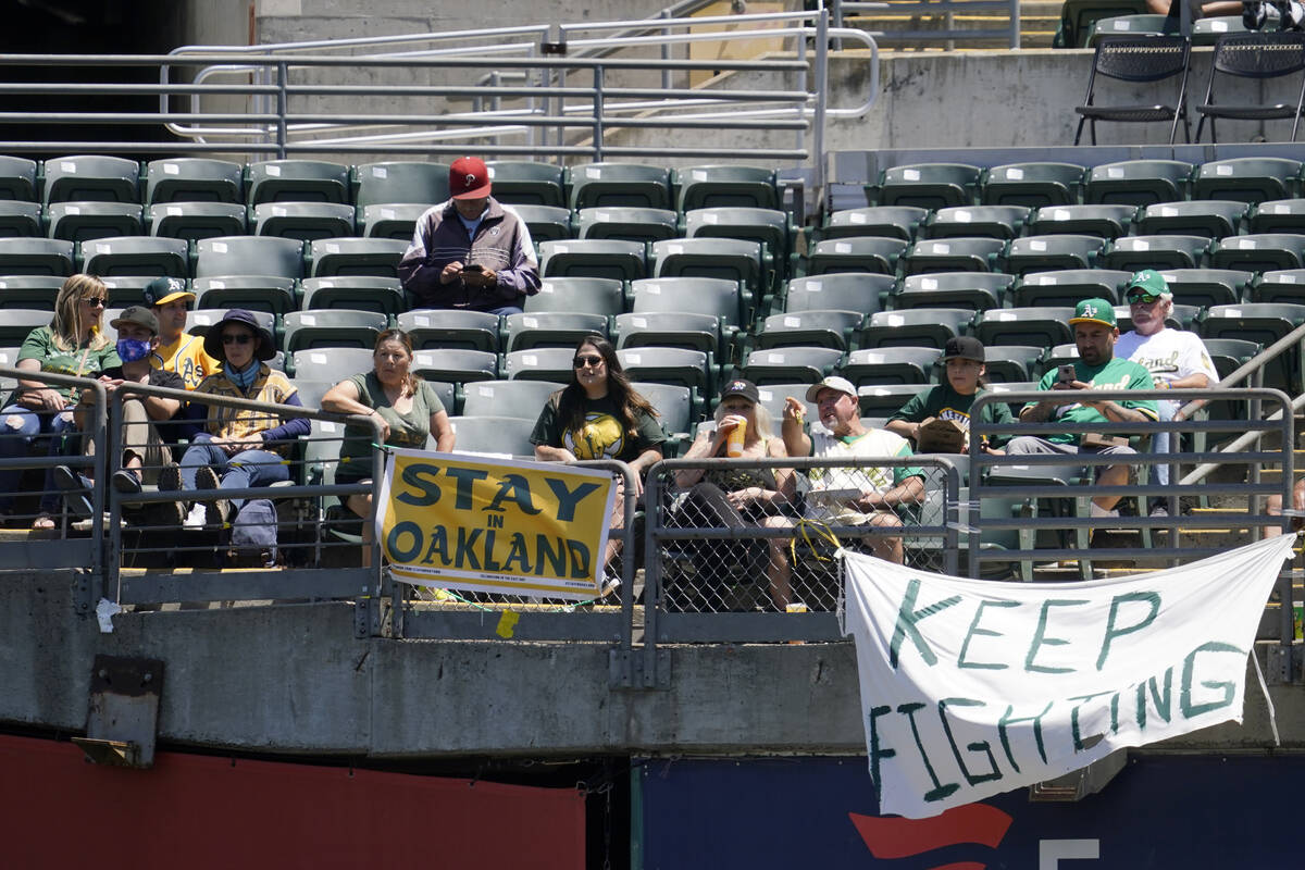 Los aficionados se sientan detrás de un cartel que dice "Stay in Oakland" durante la primera e ...