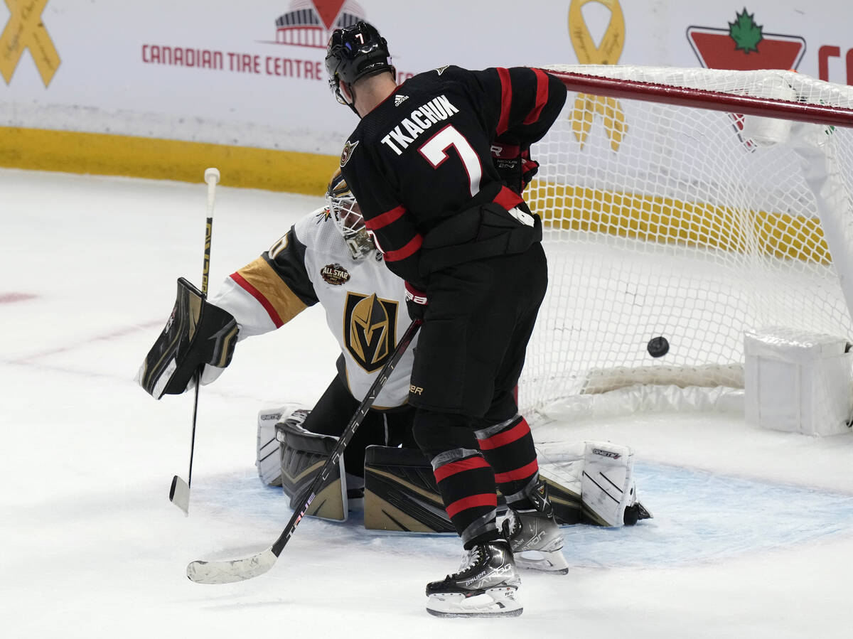 El ala izquierda de los Ottawa Senators, Brady Tkachuk, pasa el puck por encima del portero de ...