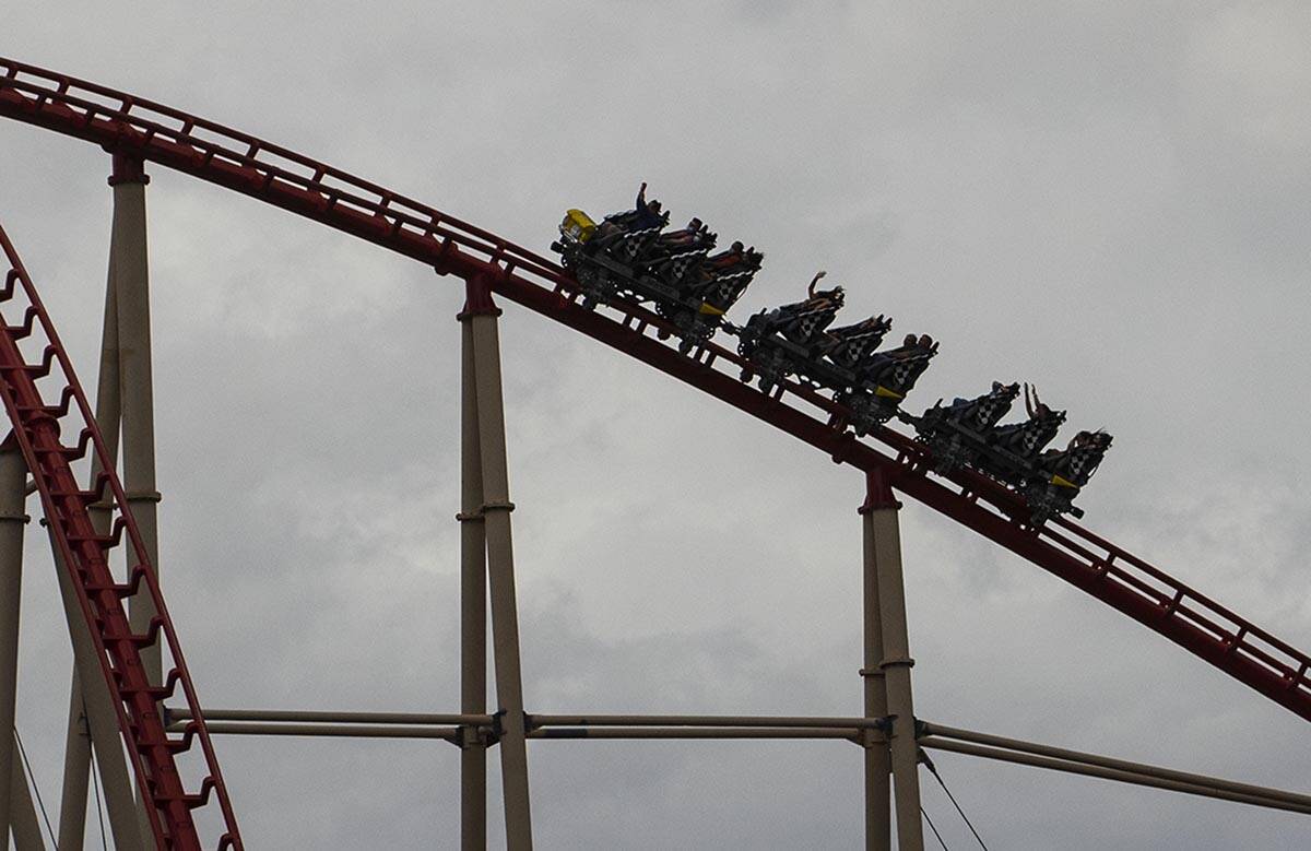 Turistas montan una montaña rusa bajo un cielo nublado en el hotel y casino New York-New York, ...