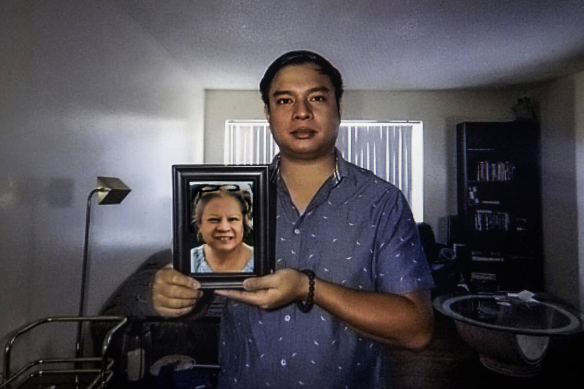 Roderick Alimusa sostiene una fotografía de su madre, María Alimusa, en su casa de Westminste ...