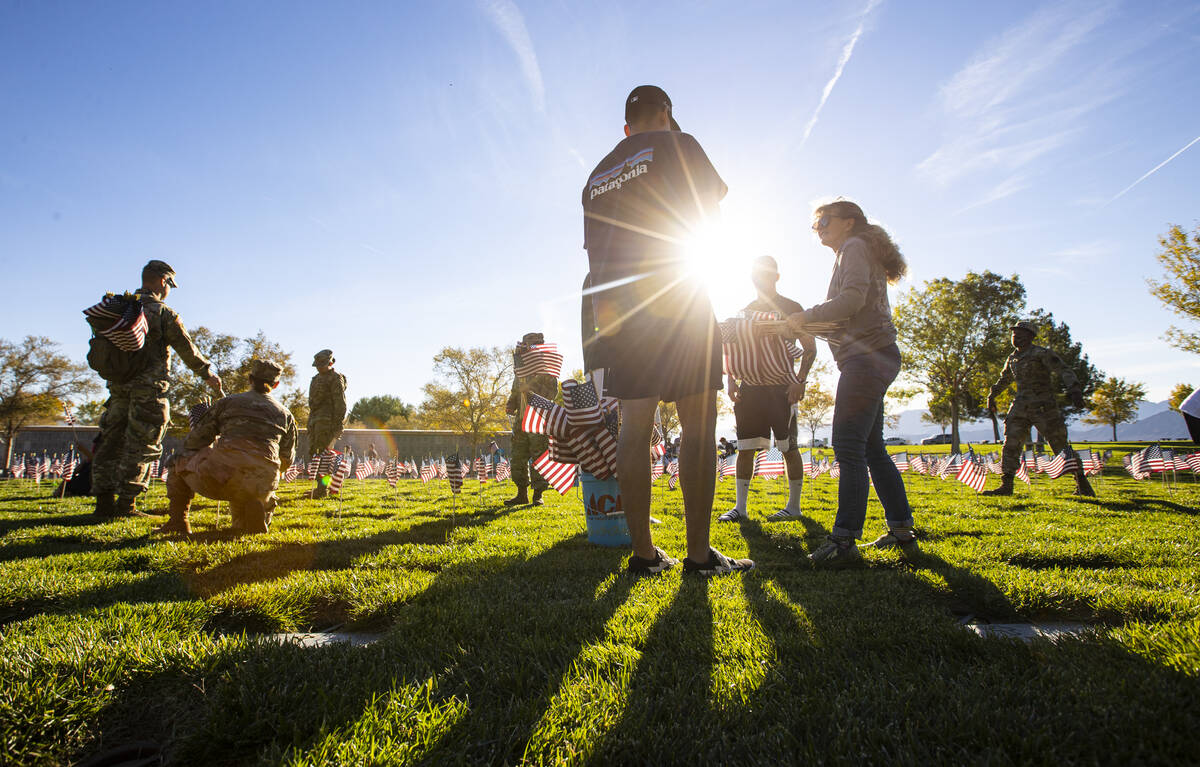 Voluntarios colocan banderas estadounidenses en las tumbas del Southern Nevada Veterans Memoria ...