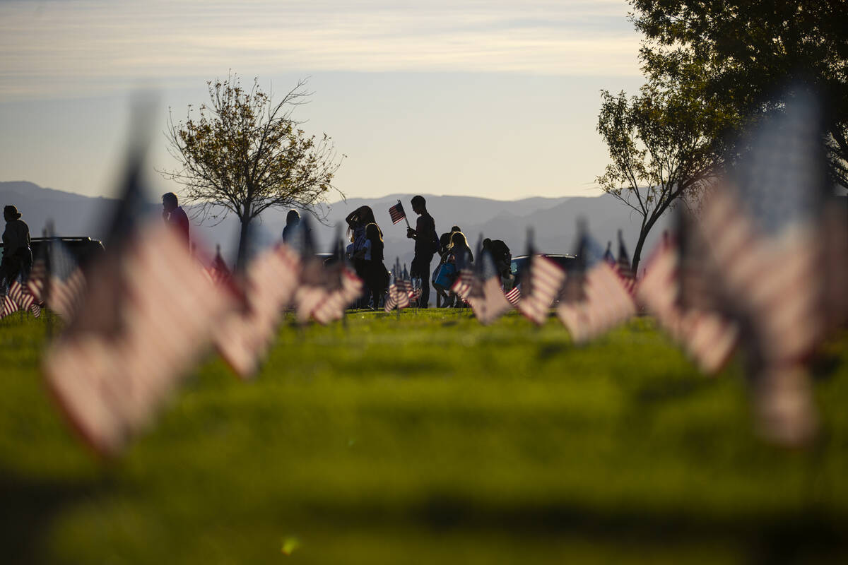 Voluntarios colocan banderas estadounidenses en las tumbas del Southern Nevada Veterans Memoria ...