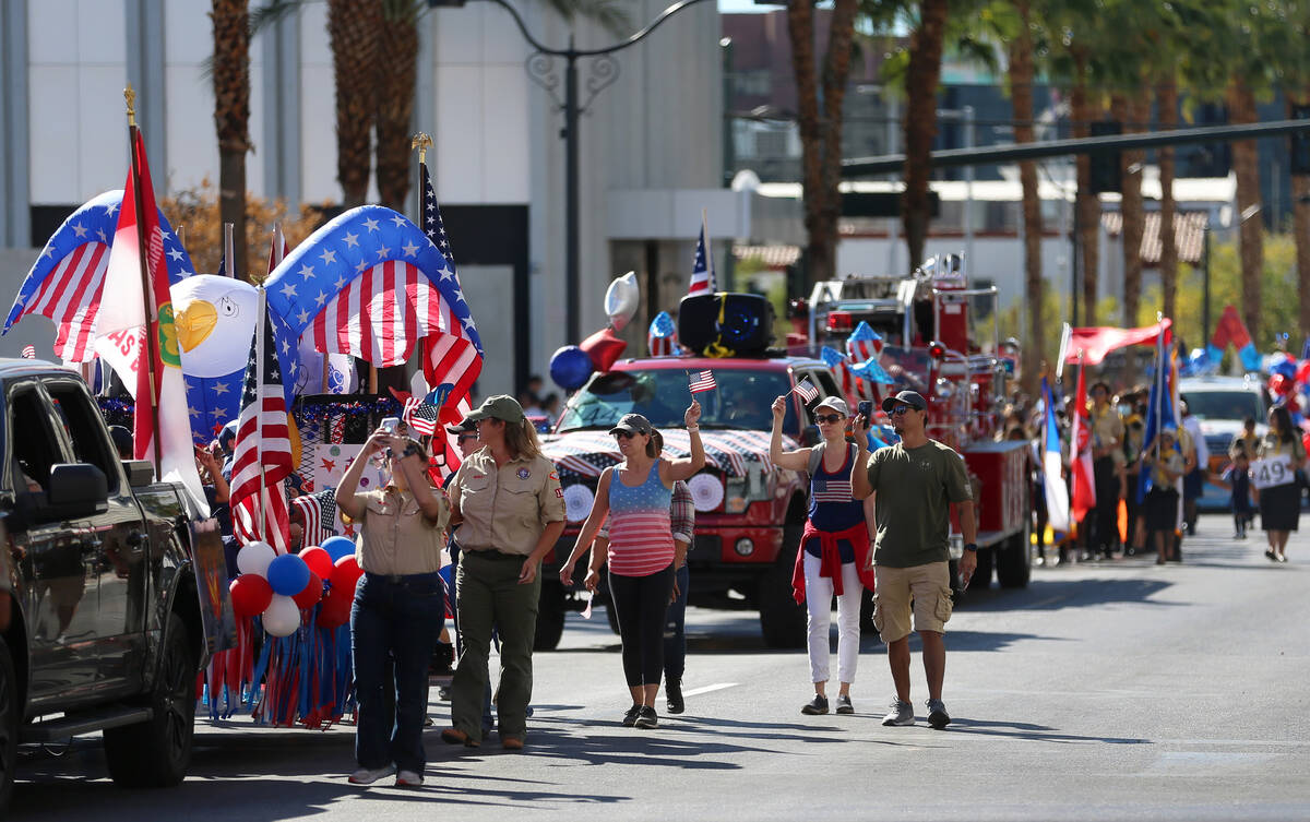 Participantes se abren paso por la ruta del desfile del Día de los Veteranos en 4th Street en ...