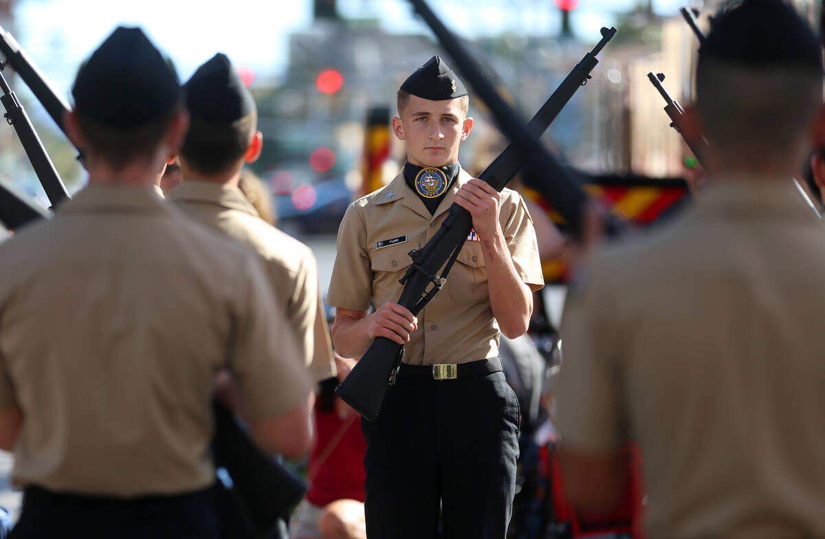 El ROTC junior de Centennial High School participa durante el desfile del Día de los Veteranos ...