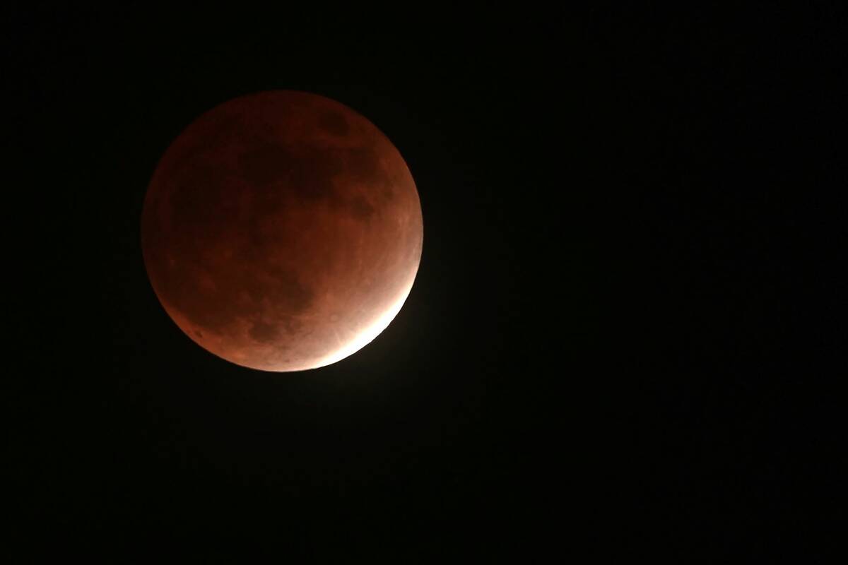 La sombra de la Tierra cubre la Luna durante un eclipse lunar parcial el viernes 19 de noviembr ...