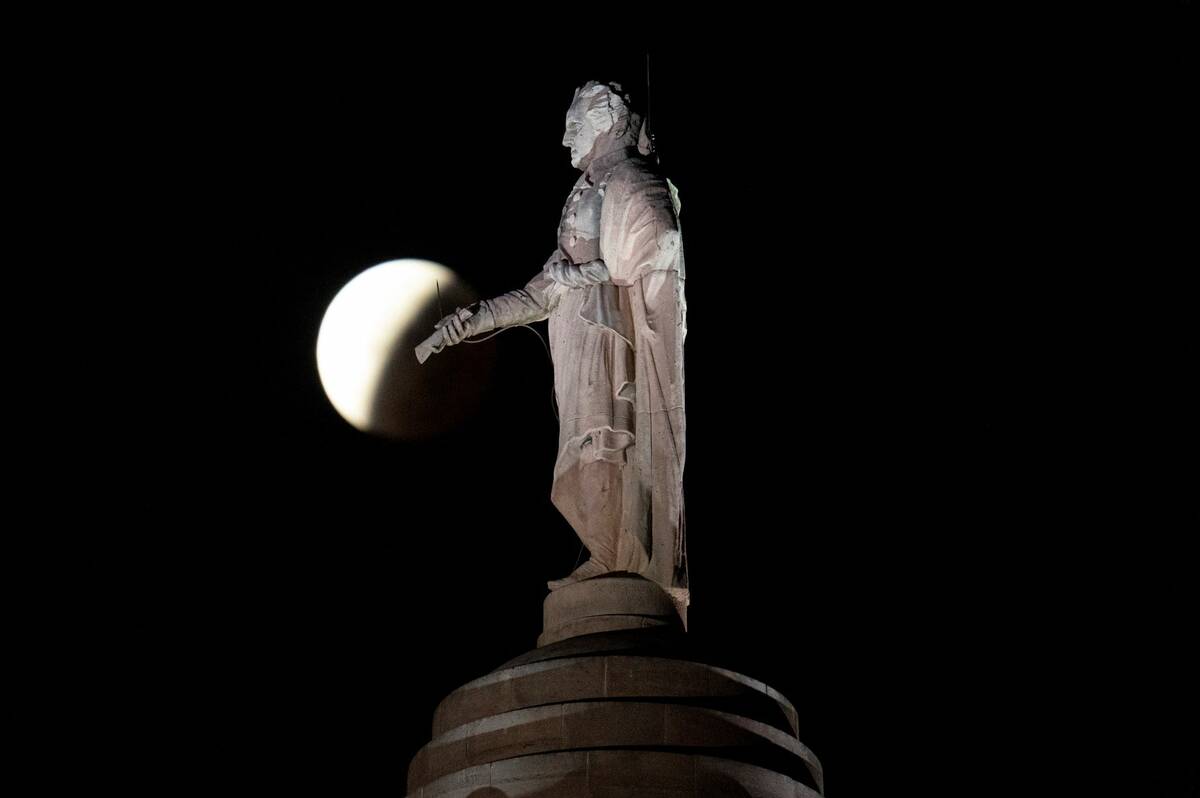 La sombra de la tierra cubre la luna llena durante un eclipse lunar parcial visible cerca de un ...