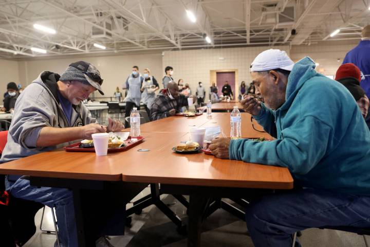 Gary Nichols, de 61 años, a la izquierda, y Leo Nino, de 58, comen una comida gratuita de Than ...