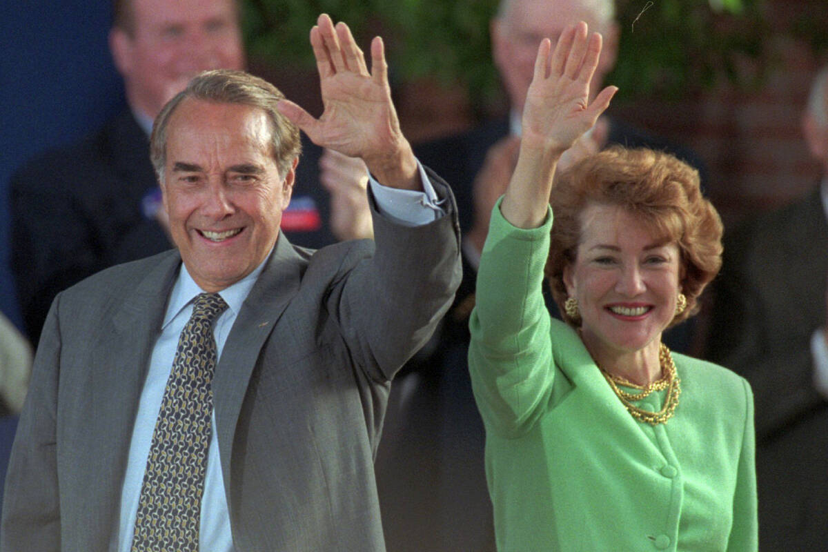 ARCHIVO - El candidato presidencial republicano Bob Dole y su esposa Elizabeth saludan a los si ...