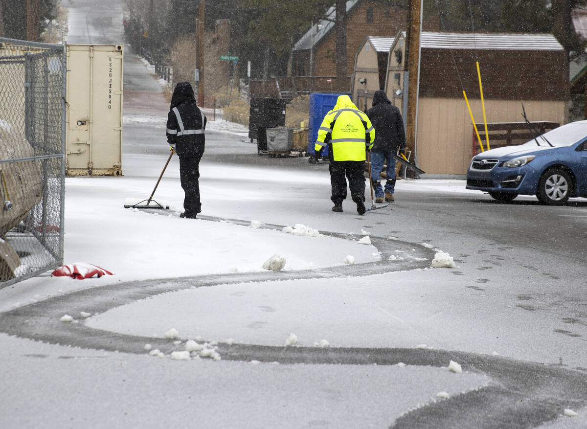 Trabajadores de las cabañas de Mt. Charleston Lodge retiran la nieve de un coche estacionado m ...