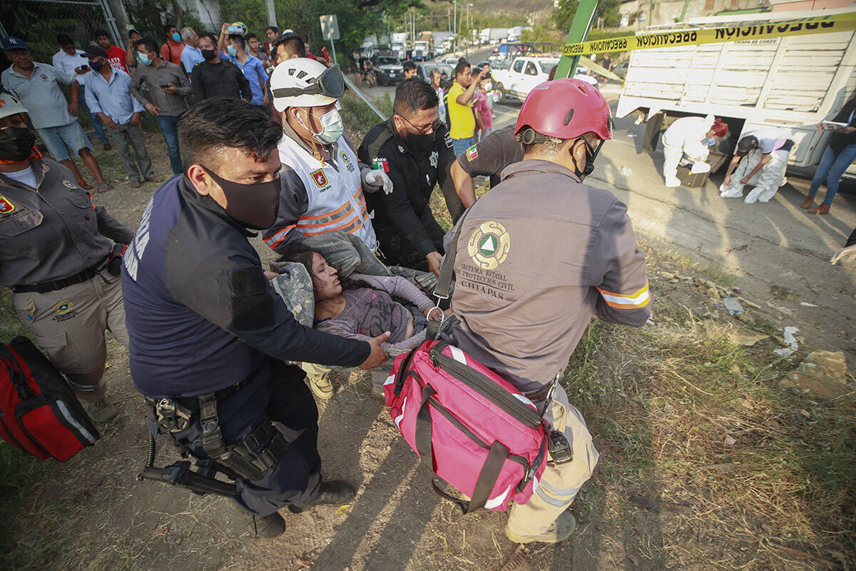 Una mujer migrante lesionada es trasladada por personal de rescate del lugar de un accidente ce ...