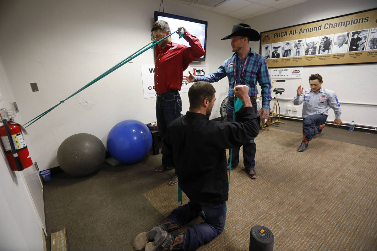El ex competidor de rodeo Doug Champion, con sombrero de vaquero, hace terapia física con los ...