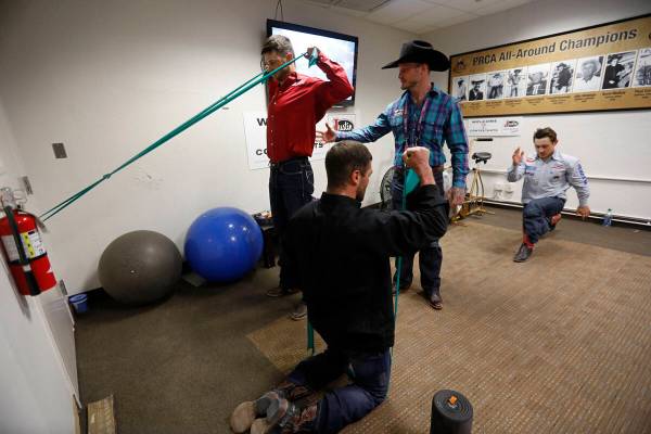 El ex competidor de rodeo Doug Champion, con sombrero de vaquero, hace terapia física con los ...