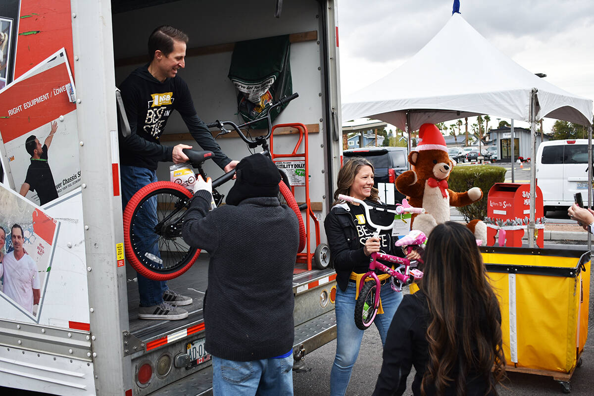 Voluntarios ayudan a descargar un camión con juguetes destinados a la colecta de la estación ...