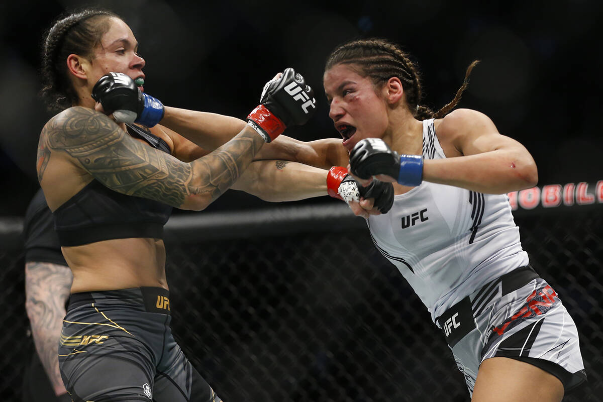 Julianna Peña, derecha, golpea a Amanda Nunes durante una pelea por el título de artes marcia ...