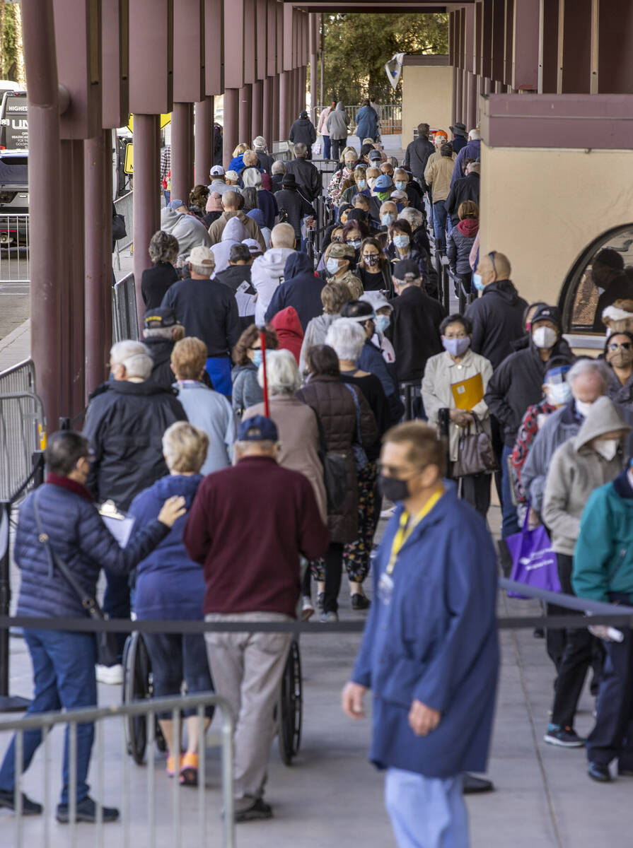 Gente camina mientras hace fila para entrar en el Cashman Center para recibir las vacunas contr ...
