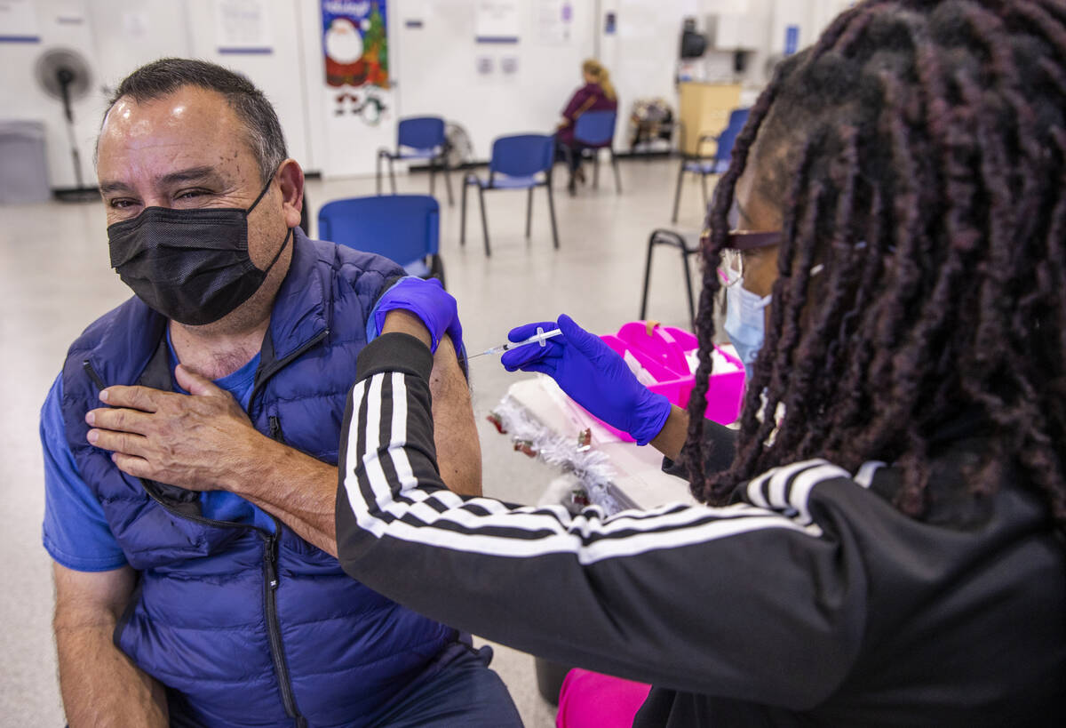 José Grajeda, a la izquierda, es vacunado por Adwoa Fosu en la clínica de vacunación COVID-1 ...