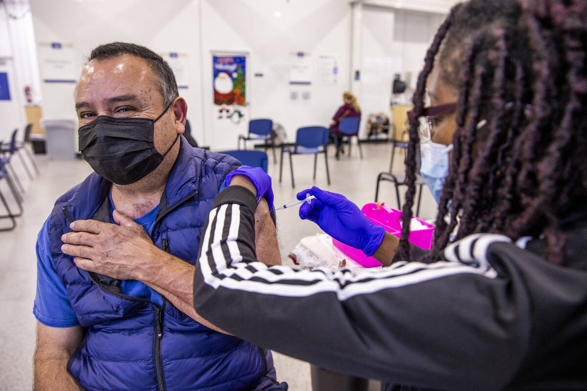 José Grajeda, a la izquierda, es vacunado por Adwoa Fosu en la clínica de vacunación COVID-1 ...