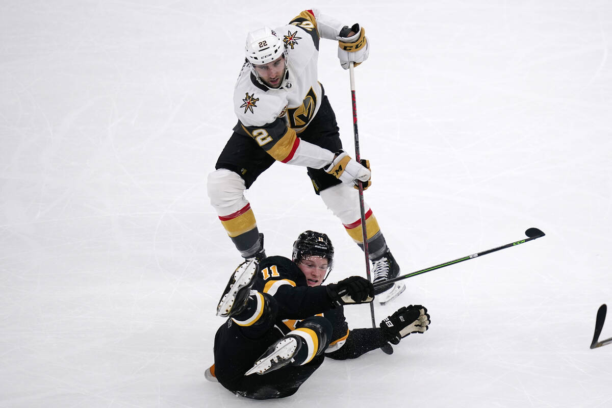 El centro de los Boston Bruins Trent Frederic (11) cae al hielo mientras lucha con el centro de ...