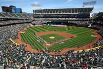 Los Angeles Angels y los Oakland Athletics se ponen de pie para el himno nacional en el Oakland ...