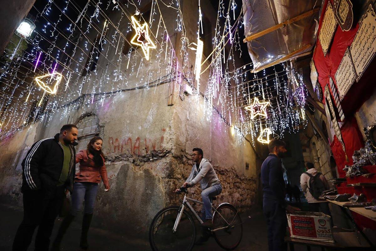 Gente camina en la Ciudad Vieja de Damasco, Siria, decorada para las próximas fiestas navideñ ...