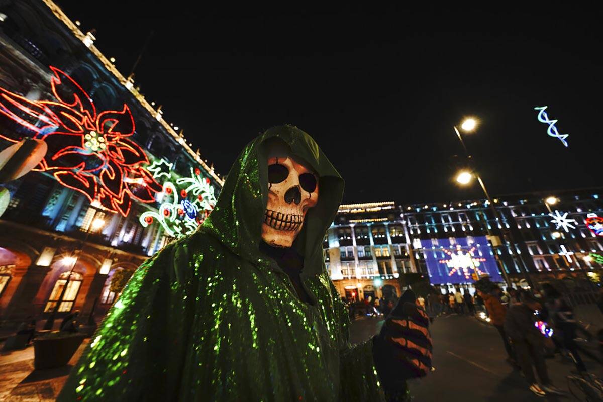 Una persona vestida de La Santa Muerte posa para una foto en la plaza principal de la Ciudad de ...