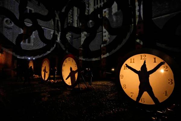 Visitantes interactúan con iluminación de relojes en el recorrido de luces "Palace of Stardus ...