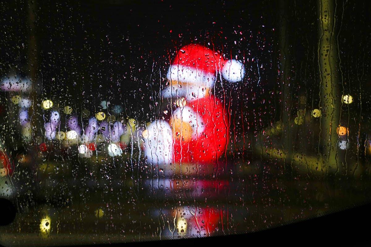 Gotas de lluvia en la ventana de un coche tienen como telón de fondo las luces de la ciudad y ...