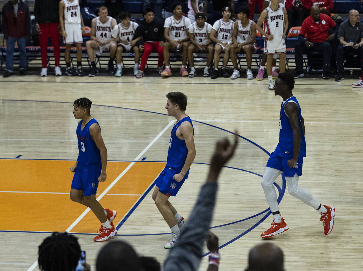 John Mobley Jr. de Bishop Gorman (izquierda) celebra con sus compañeros de equipo después de ...