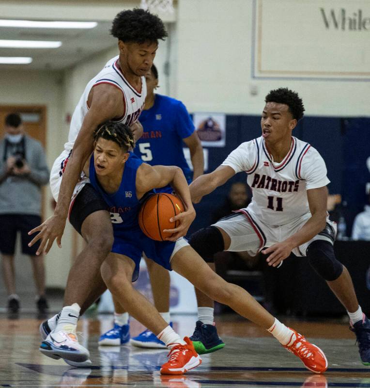 John Mobley Jr. (3) de Bishop Gorman intenta pasar por delante de Joshua Jefferson (5) y Dedan ...