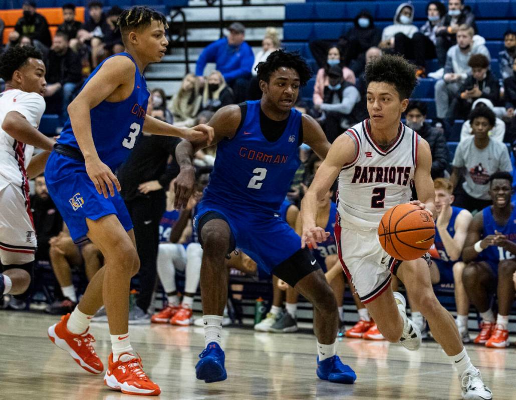 El jugador de Liberty High Angelo Kambala (2) contra los jugadores de Bishop Gorman John Mobley ...