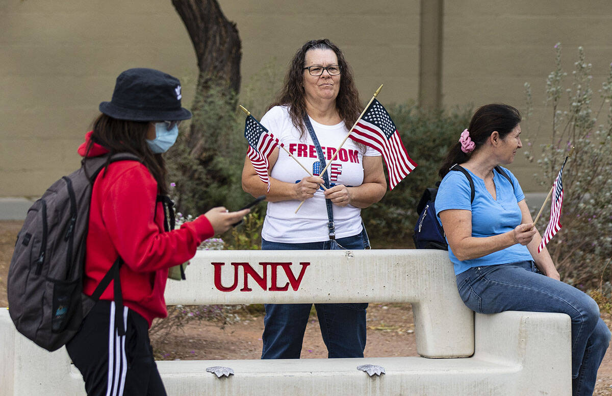 Un estudiante de la UNLV pasa junto a los manifestantes, entre ellos Susie K. de Las Vegas, a l ...