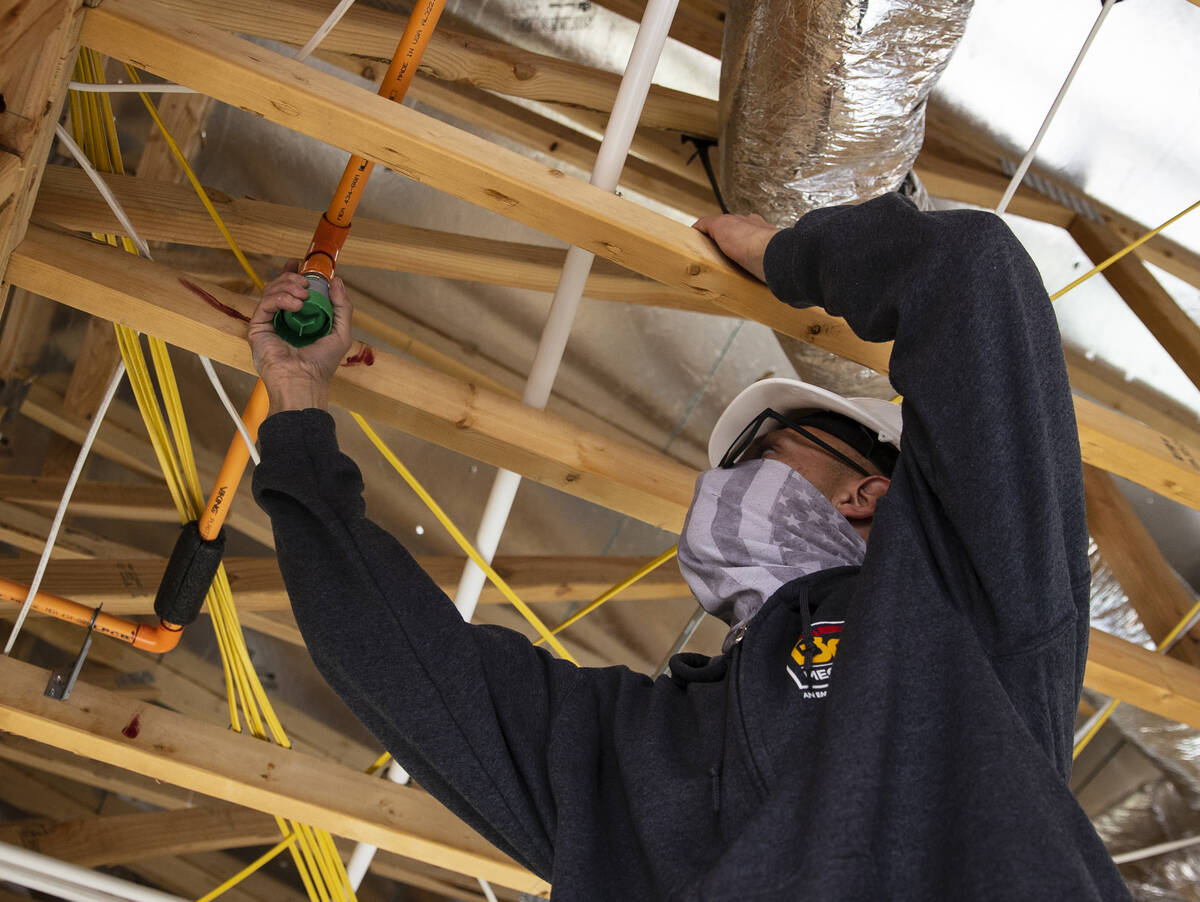 Julián Hernández, de B2C Mechanical, trabaja en un sistema de rociadores en Lennar at Heritag ...