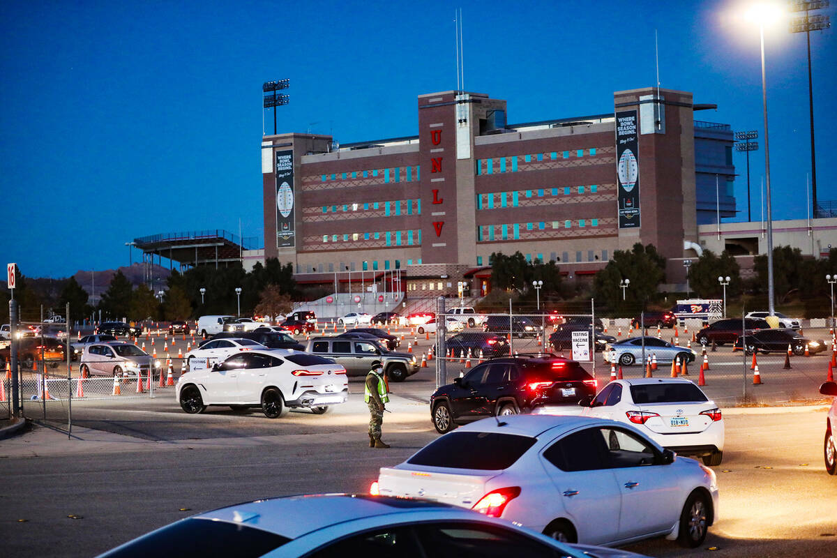 La gente espera en la fila para la clínica de pruebas y vacunas de COVID-19 en Sam Boyd Stadiu ...