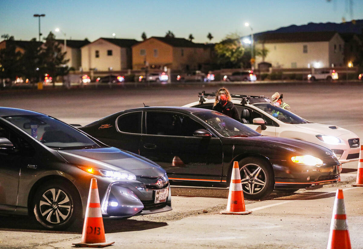 La gente espera en la fila para la clínica de pruebas y vacunas COVID-19 en Sam Boyd Stadium e ...