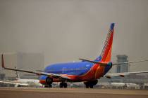 Un avión de Southwest Airlines se prepara para despegar mientras otros se mueven por la pista ...
